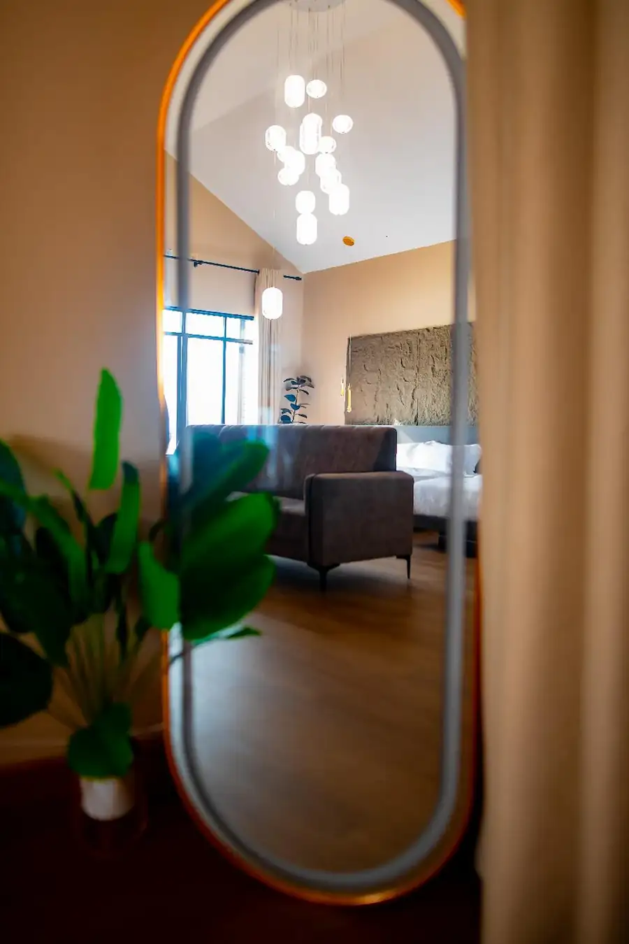 Tall standing mirror reflecting the comfortable living area and beds inside the Family Room at Turtle Seaweed Resort.